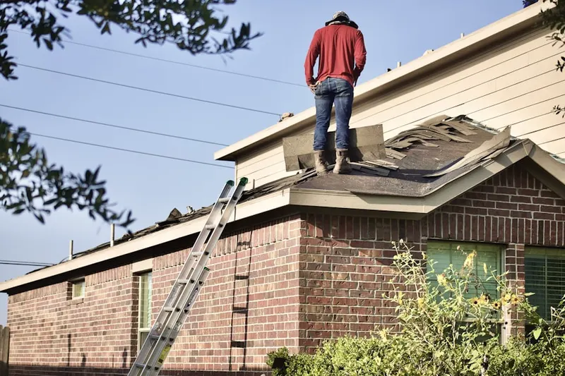 Professional roofer working on a residential roof in Point Breeze